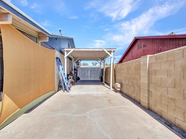 view of patio / terrace with a gate, fence, and driveway