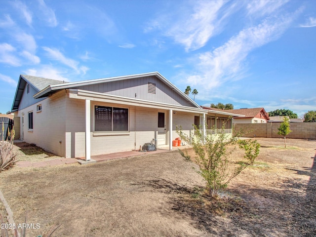 view of front of house with concrete block siding and a fenced backyard