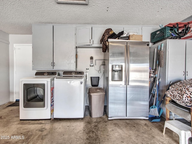 washroom featuring cabinet space, separate washer and dryer, and a textured ceiling