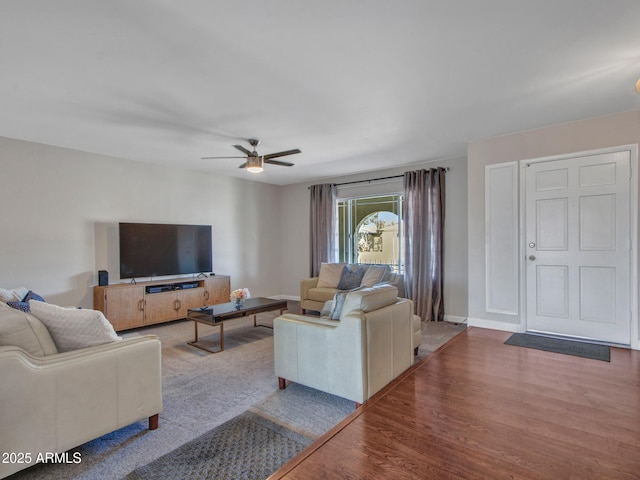 living room with ceiling fan, wood finished floors, and baseboards