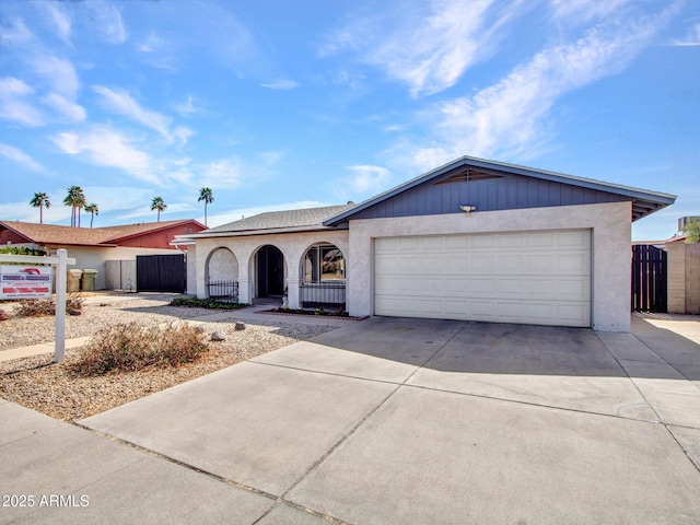 view of front of house featuring an attached garage, driveway, fence, and stucco siding