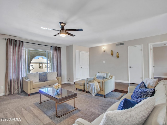 living room featuring ceiling fan, visible vents, and baseboards