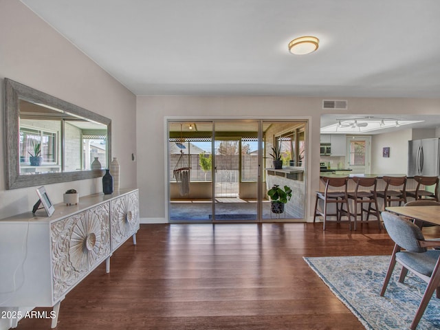 interior space with dark wood-style flooring, visible vents, and baseboards