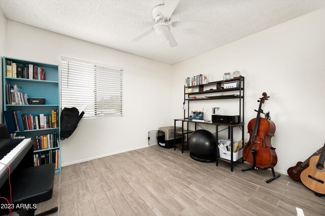 office area featuring ceiling fan, light wood-type flooring, and a textured ceiling