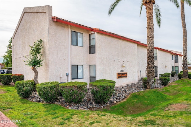 view of property exterior with a lawn