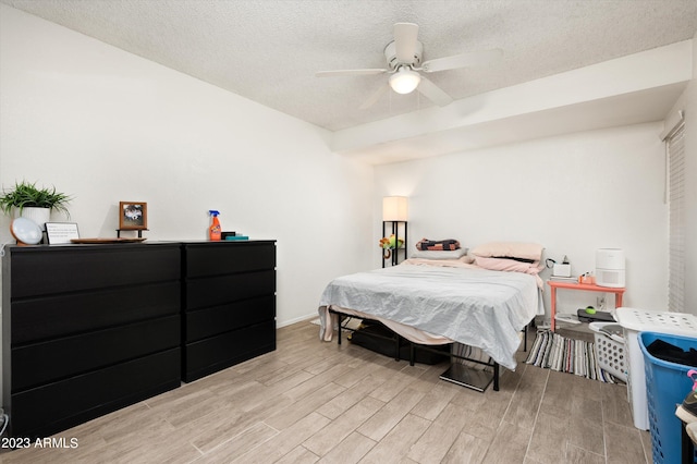 bedroom featuring ceiling fan, light wood-type flooring, and a textured ceiling