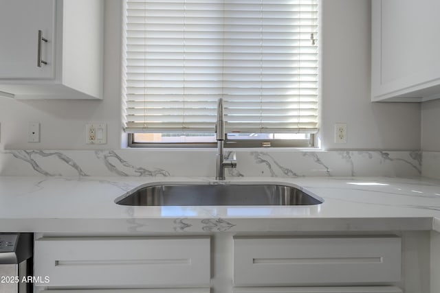 kitchen featuring white cabinetry, light stone countertops, sink, and dishwashing machine