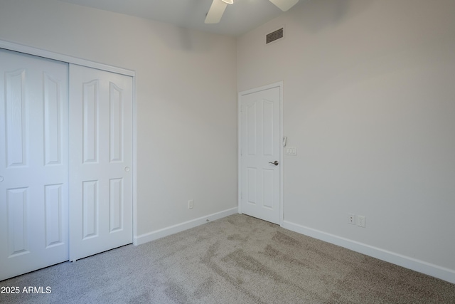 unfurnished bedroom featuring ceiling fan, a closet, and light colored carpet