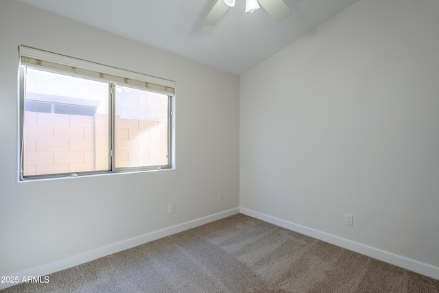 carpeted spare room with ceiling fan and vaulted ceiling