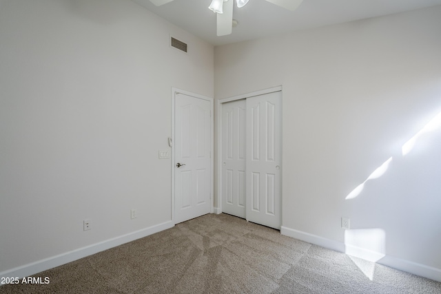 unfurnished bedroom featuring ceiling fan, light colored carpet, and a closet