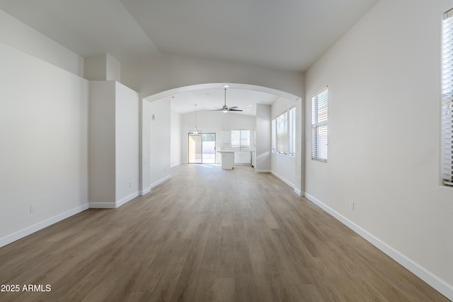 unfurnished living room featuring hardwood / wood-style floors, ceiling fan, and vaulted ceiling