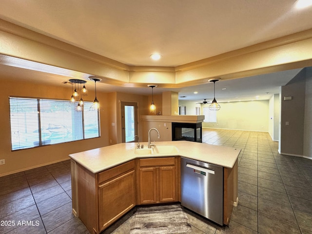 kitchen with a sink, open floor plan, light countertops, stainless steel dishwasher, and an island with sink