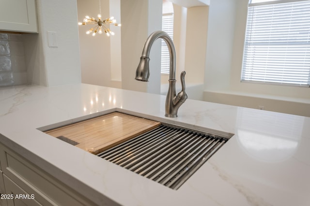 866 W Geronimo St, Chandler, AZ 85225 - kitchen view of a chandelier, a sink, and light stone countertops