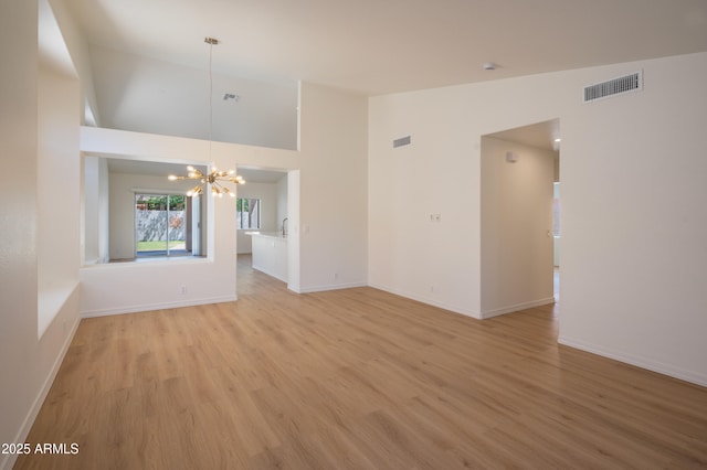 866 W Geronimo St, Chandler, AZ 85225 - unfurnished living room with a chandelier, light wood-style floors, baseboards, and high vaulted ceiling