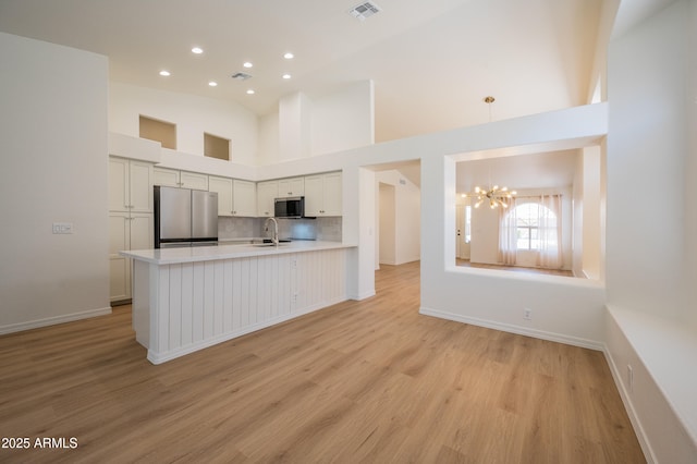 866 W Geronimo St, Chandler, AZ 85225 - kitchen with appliances with stainless steel finishes, light countertops, a chandelier, light wood-type flooring, and recessed lighting