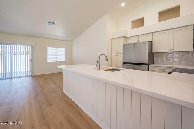 866 W Geronimo St, Chandler, AZ 85225 - kitchen with freestanding refrigerator, a sink, vaulted ceiling, light wood finished floors, and decorative backsplash