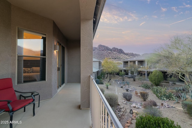 balcony at dusk featuring a mountain view