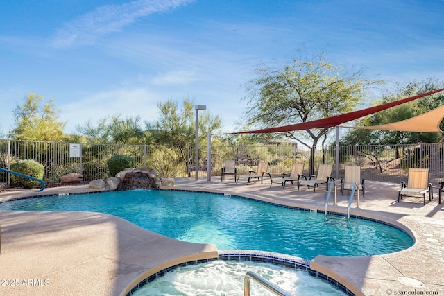 view of pool with a hot tub, pool water feature, and a patio area