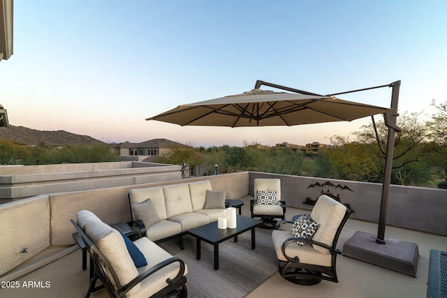 patio terrace at dusk featuring a balcony and an outdoor hangout area