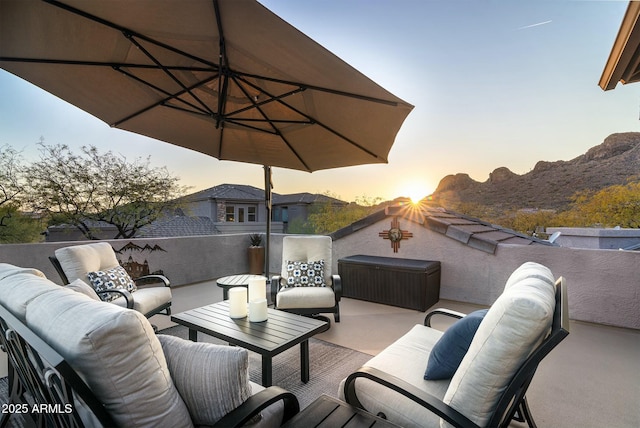 patio terrace at dusk with an outdoor living space and a balcony