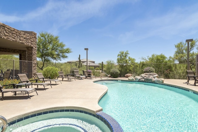 view of pool featuring a patio and an in ground hot tub