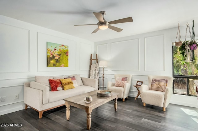 sitting room with dark wood-type flooring, a decorative wall, and a ceiling fan