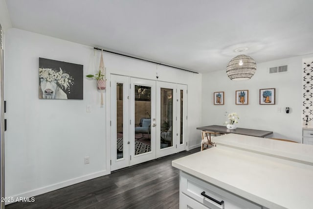 kitchen with dark wood-type flooring, visible vents, white cabinetry, light countertops, and french doors