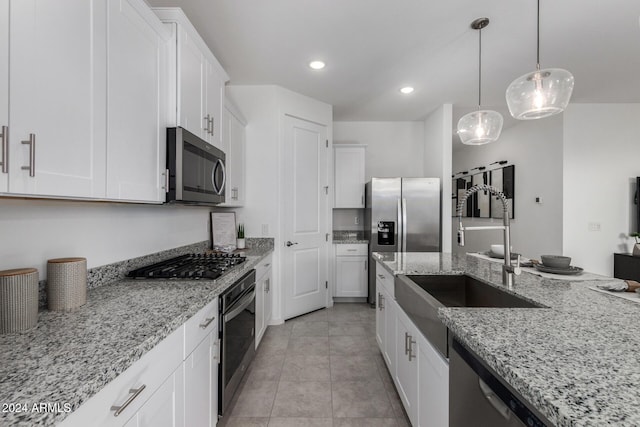 kitchen with light stone countertops, appliances with stainless steel finishes, and white cabinetry