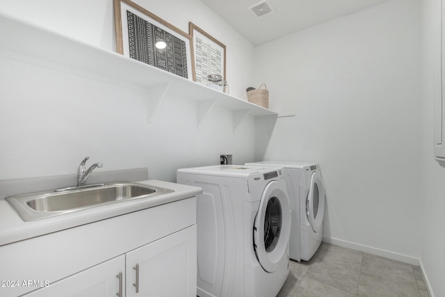 laundry room featuring cabinets, sink, and washing machine and clothes dryer