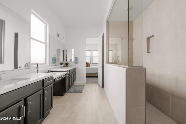 bathroom featuring tiled shower, vanity, and hardwood / wood-style floors