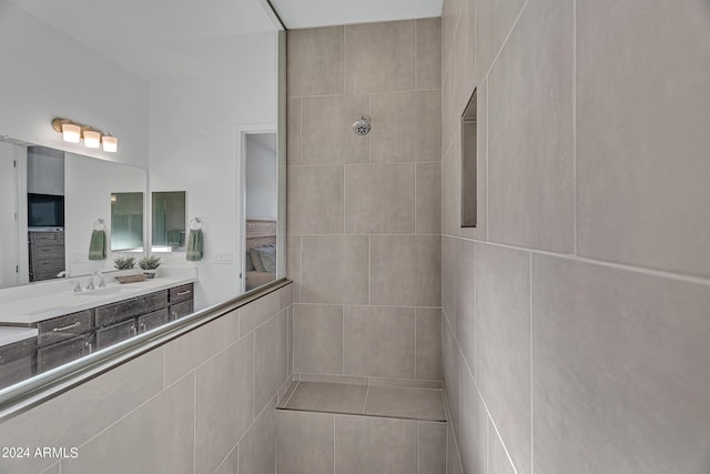 bathroom with vanity and tiled shower