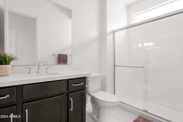 bathroom featuring vanity, an enclosed shower, and toilet