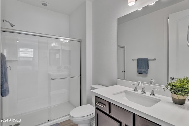 bathroom featuring walk in shower, vanity, and toilet