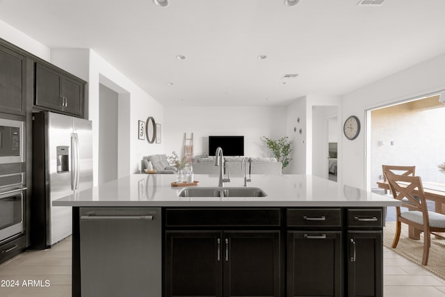 kitchen with appliances with stainless steel finishes, sink, and a center island with sink