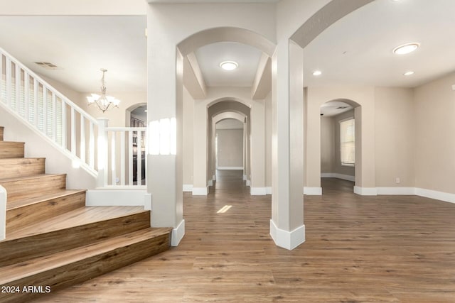 entryway with hardwood / wood-style floors and an inviting chandelier