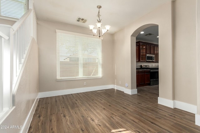 unfurnished dining area featuring dark hardwood / wood-style flooring and an inviting chandelier