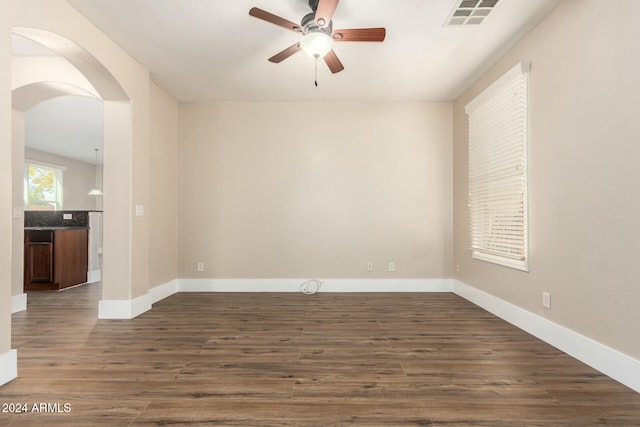 unfurnished room with ceiling fan and dark wood-type flooring