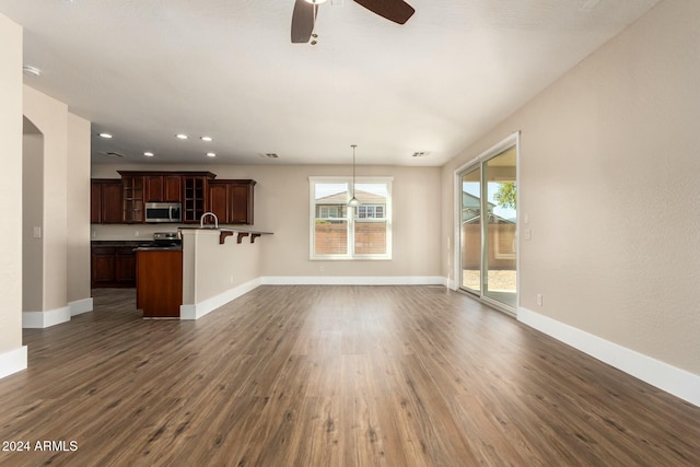 unfurnished living room with ceiling fan and dark hardwood / wood-style floors