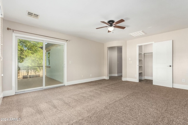 unfurnished bedroom featuring carpet flooring, a walk in closet, access to outside, ceiling fan, and a closet