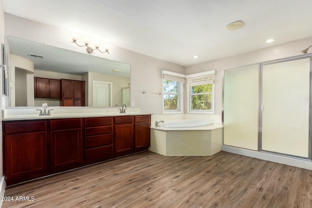 bathroom with hardwood / wood-style flooring, vanity, and shower with separate bathtub