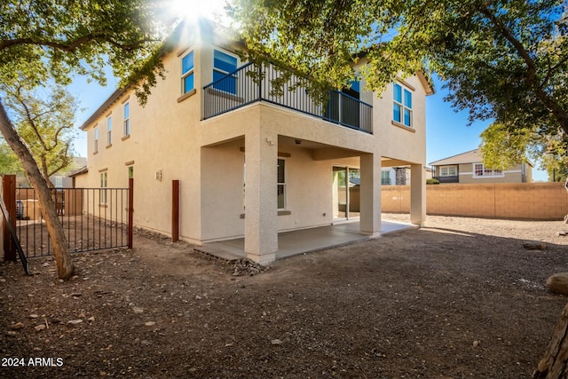 rear view of house with a balcony and a patio