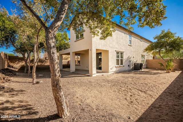 rear view of house featuring central AC unit, a patio area, and a balcony