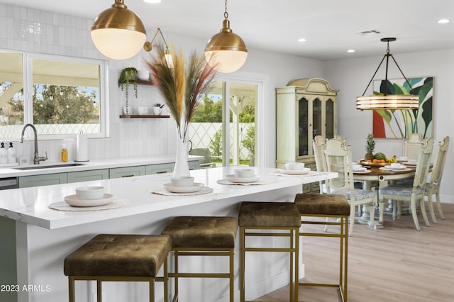 kitchen with decorative light fixtures, sink, and a breakfast bar