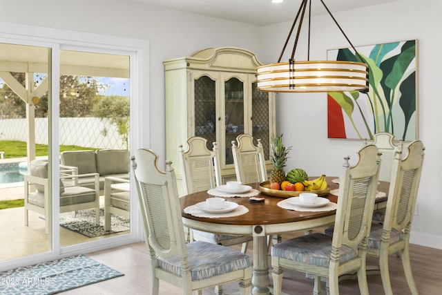 dining space with wood-type flooring and a notable chandelier