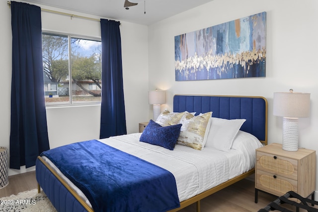 bedroom featuring wood-type flooring, multiple windows, and ceiling fan