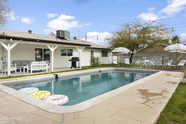 view of pool with outdoor lounge area, a patio area, and cooling unit