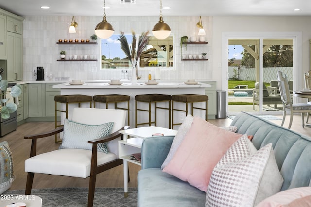 bar featuring backsplash, hardwood / wood-style flooring, hanging light fixtures, and green cabinets