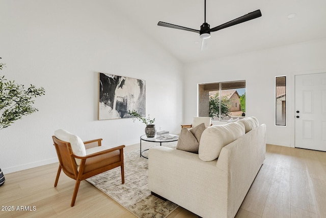 living room featuring ceiling fan, wood-type flooring, and a high ceiling