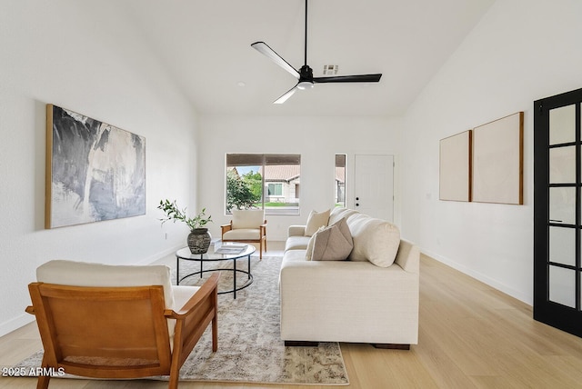 living room featuring ceiling fan, light hardwood / wood-style floors, and high vaulted ceiling