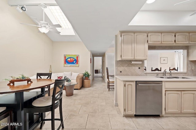 kitchen with tasteful backsplash, ceiling fan, stainless steel dishwasher, a skylight, and sink